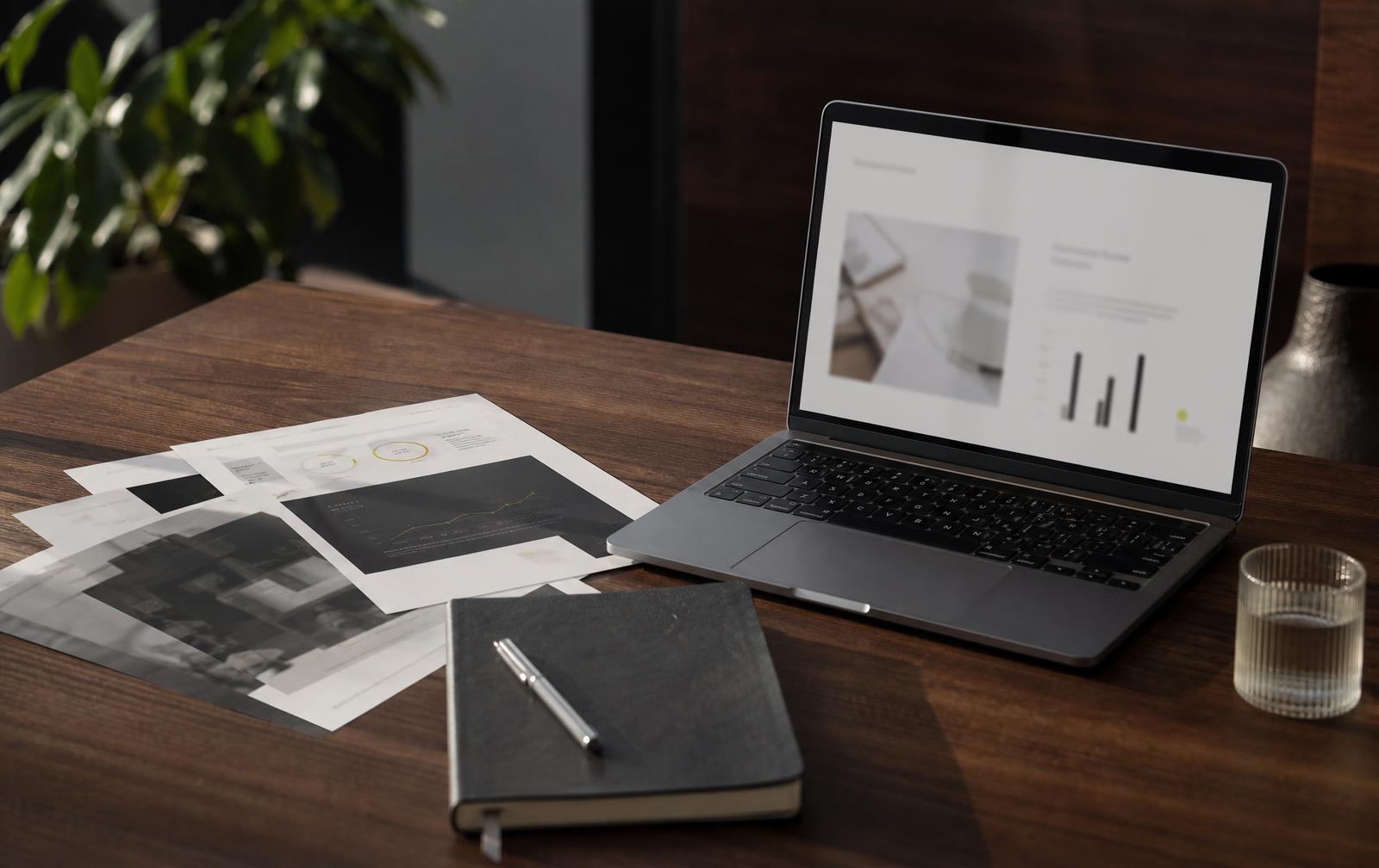 MacBook y diapositivas impresas sobre escritorio de nogal, sistema de presentaciones